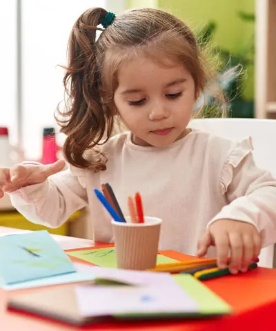 Child engaged in creative learning activities at a nursery in Dubai focused on early development