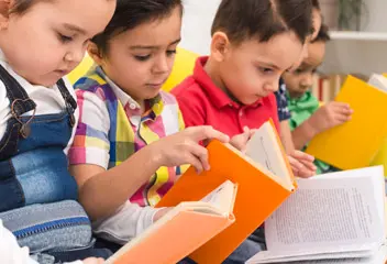 Children developing literacy and reading skills through engaging classroom activities in Dubai